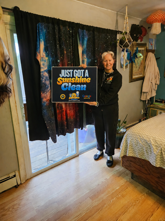 Crystal holding a Just Got A Sunshine Clean sign